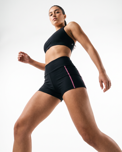 A high-end commercial product photograph of a young model in a dynamic, confident pose, captured from a dramatic angle shot to emphasize the product.  Studio lighting with white background. Shot on a 35mm lens, f/2.8, sharp focus on the product details, hyper-realistic textures, professional color grading with clean, modern tones, 8k resolution, no shadows @Women's High Waisted Yoga Biker Shorts